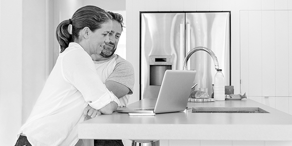 Man and woman looking at computer together smiling