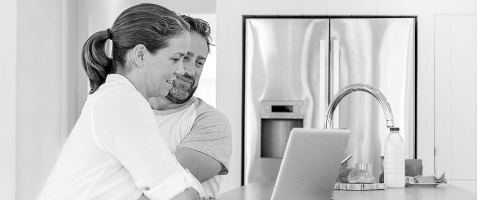 Man and woman looking at computer together smiling