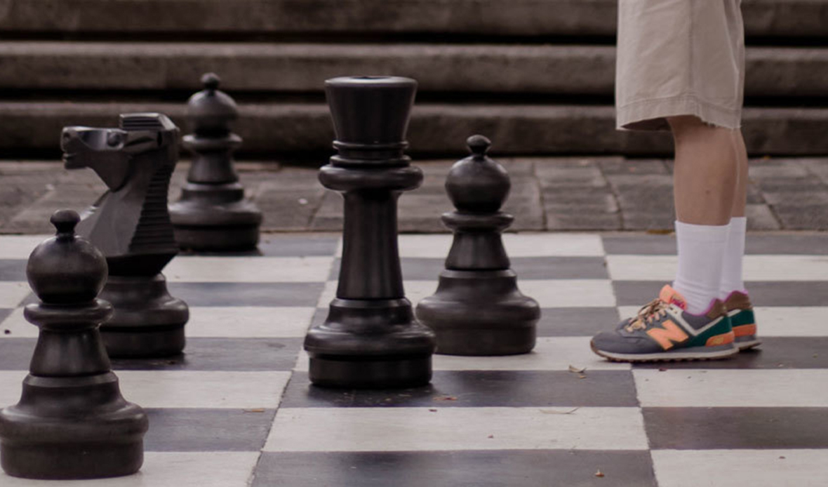 Large chess board with pawns facing human